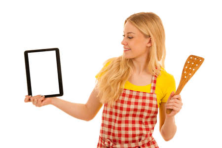 Young blond woman chef showing tablet with a recepy isolated over white backgroundの写真素材