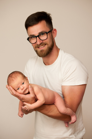 Father holding new born baby on his armの写真素材