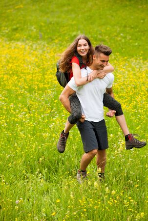 active Playful coupel hiking on a meadow in ratly spring green grass fieldの写真素材