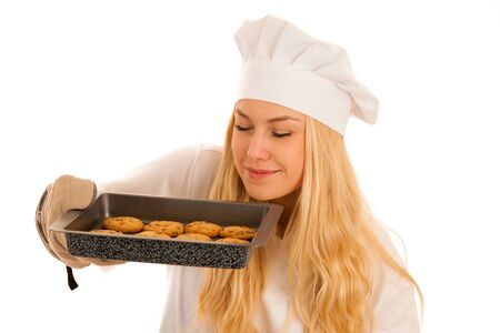 beautiful blond woman in chef dress bakes cookies isolated over white backgroundの写真素材