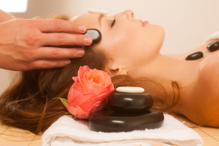 attractive young beautiful woman having facial massage with mineral stoneの写真素材