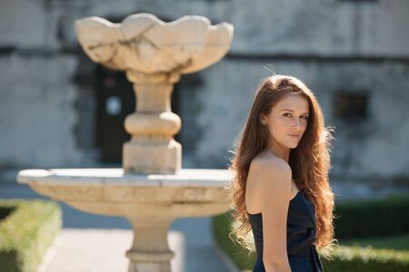 Beautiful young woman model in blue dress posing outdoor in the park.の写真素材