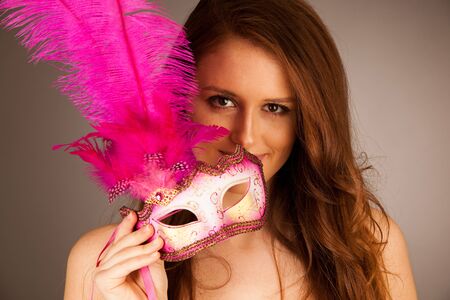 atractive young woman with venice mask studio portraitの写真素材
