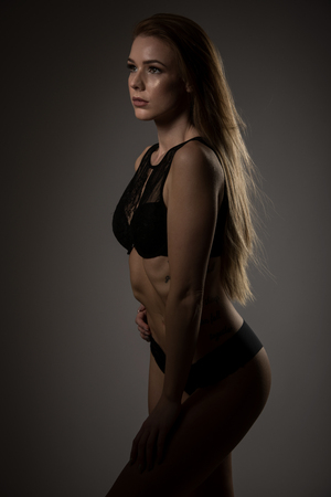 Boudoir photography of a beautiful young woman over dark backgroundの写真素材
