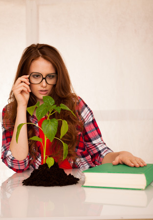 attractive young botany student with seedlnng and booksの写真素材