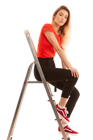 Beautiful Woman,  Girl Wearing red t shirt  Portrait Of Sexy Female With Beauty Face  Posing Near metal Ladder In Studio isolated over whiteの写真素材