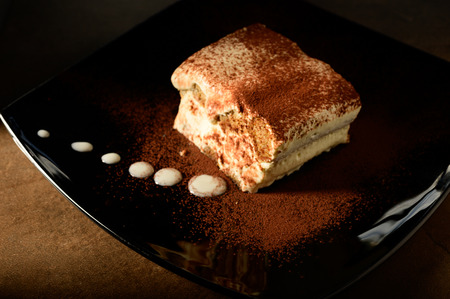 Piece of appetizing tiramisu cake on plate in close upの写真素材