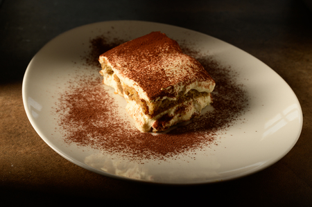 Piece of appetizing tiramisu cake on plate in close upの写真素材