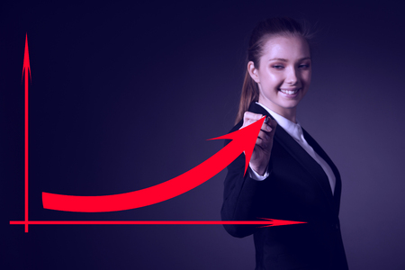 Beautiful business woman draws with marker on virtual screen with copy space for additional graphicの写真素材