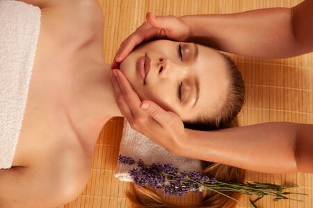 Beautiful young woman having a face massage in spa salon - wellness .の写真素材