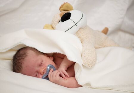 Baby boy sleep with soother in mouthの写真素材