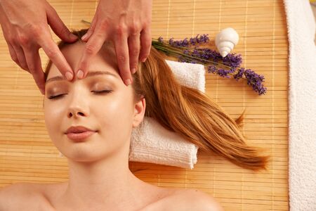 Beautiful young woman having a face massage in spa salon - wellness .の写真素材