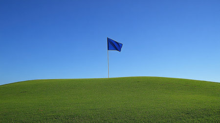 Golf flag in motion with wind captured on a breezy course under clear blue skiesの素材