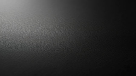 High-resolution black paper background with delicate grain and soft lightingの素材