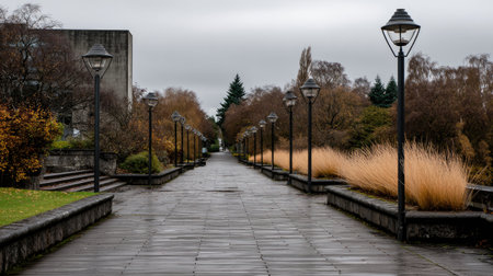 A tranquil pathway lined with vintage street lamps invites exploration, surrounded by lush autumn foliage under a moody overcast sky.の素材