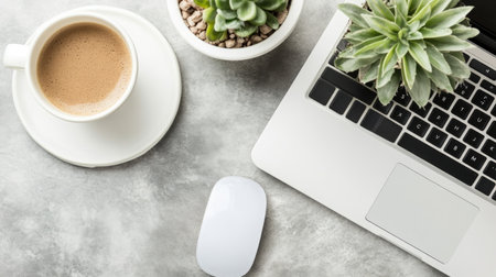 A serene workspace featuring a laptop, a cup of coffee, and succulent plants on a gray table. Perfect for creating a cozy and productive environment.の素材