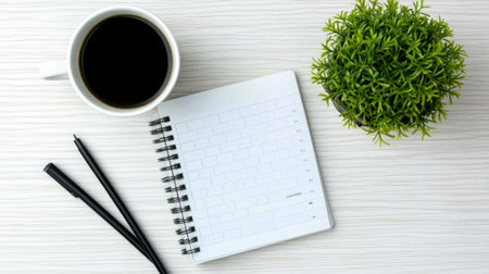 A peaceful desk setup featuring a cup of coffee, an open notebook, a pen, and a small green plant. Ideal for capturing the essence of productivity and inspiration.の素材