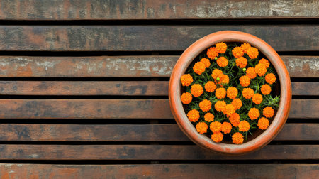 A vibrant clay pot filled with bright orange flowers rests on a rustic wooden surface, creating a harmonious blend of nature and design. Perfect for garden themes.の素材