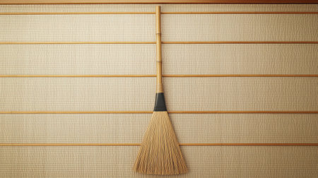 A minimalist broom hangs against a textured wall, showcasing simplicity and elegance. This image highlights natural materials and clean design, perfect for interiors.の素材