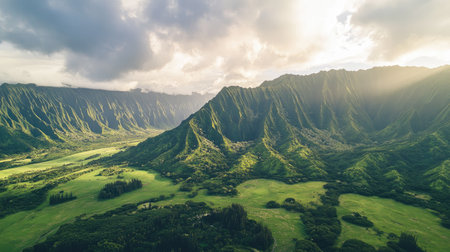 Experience a stunning aerial view of lush green mountains and valleys illuminated by soft sunlight, creating a tranquil and picturesque natural landscape perfect for exploration.の素材