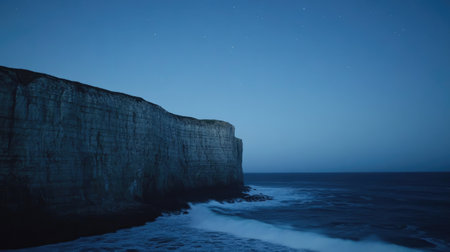 A stunning night view showcasing a rocky cliff rising majestically over gentle ocean waves, evoking tranquility and the beauty of nature at dusk.の素材