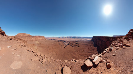 Breathtaking panoramic view of the Grand Canyon showcasing vast rock formations and a clear blue sky with bright sunlight illuminating the landscape, perfect for nature enthusiasts.の素材
