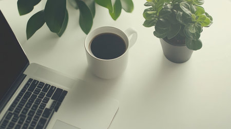 A cozy workspace featuring a coffee cup, laptop, and indoor plants, creating a serene and inspiring environment ideal for productivity and relaxation.の素材