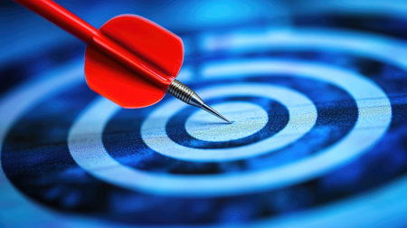 A vivid image of a red dart arrow poised at the center of a blue bullseye target, symbolizing focus, precision, and the pursuit of goals in various contexts.の素材