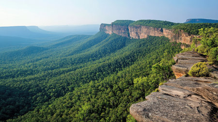 Experience the serene beauty of towering cliffs and lush green mountains under a clear sky, a perfect representation of nature's untouched wilderness.の素材