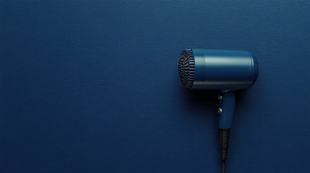 A stylish blue hair dryer rests against a dark blue textured background. This modern beauty appliance is perfect for personal grooming and enhances any bathroom decor.の素材