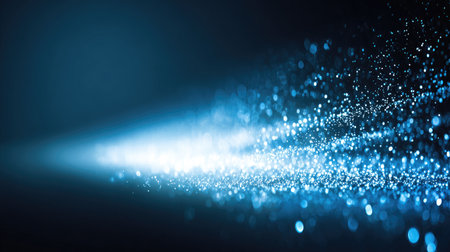 Captivating ethereal blue glitter particles dance in light rays, creating a mesmerizing background perfect for abstract themes, digital art, or atmospheric designs.の素材