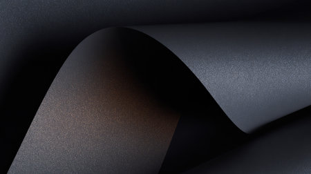 This abstract image features a close-up view of smooth curved black and dark gray paper, showcasing subtle reflections and a sleek texture suitable for various design themes.の素材