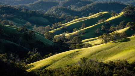 Discover the enchanting beauty of rolling hills adorned with vibrant green grass and surrounded by majestic mountains, creating a tranquil outdoor landscape.の素材