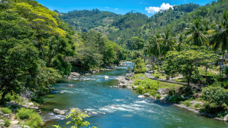 A serene river meanders through a lush landscape, surrounded by vibrant greenery and hills under a clear blue sky, perfect for nature lovers and explorers.の素材