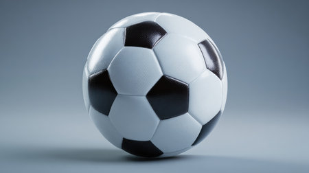 A classic soccer ball sits against a simple gray background, perfect for capturing the essence of sports, teamwork, and athleticism in various contexts and projects.の素材