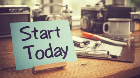 A cozy and inviting workspace featuring a motivational note that says "Start Today," surrounded by vintage cameras, writing tools, and a coffee mug, perfect for inspiring creativity.の素材