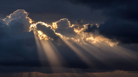 This captivating image features a stunning cloudscape where sunbeams break through dark clouds, illuminating the sky in a breathtaking display of natural beauty.の素材