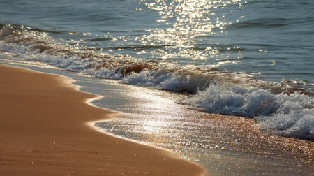 Experience the beauty of a tranquil beach scene where gentle waves kiss the golden sand under the sparkling sunlight, creating a soothing and serene atmosphere.の素材