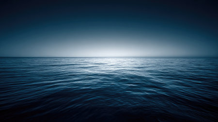 A tranquil ocean view showcases smooth water surface at dusk, seamlessly blending deep blue with light blue at the horizon, creating a serene and calming atmosphere.の素材