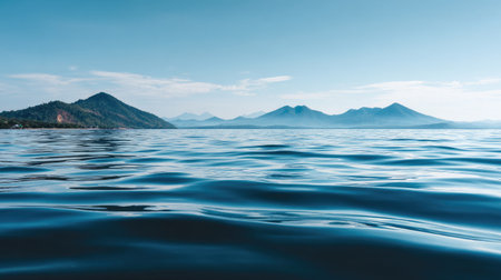 A stunning photograph featuring calm waters and majestic mountains under a clear blue sky, offering a peaceful natural landscape ideal for travel and relaxation themes.の素材