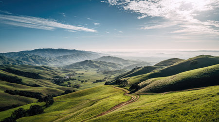 This stunning landscape captures rolling green hills under a bright blue sky with wispy clouds. The tranquility of this scene evokes a sense of peace and beauty in nature.の素材