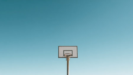 A striking image of a basketball hoop under a clear blue sky captures the essence of urban sports activity. Ideal for fitness and recreation themes.の素材