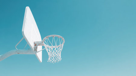 A striking basketball hoop against a bright blue sky captures the spirit of outdoor sports. Perfect for themes related to fitness, fun, and active lifestyles.の素材