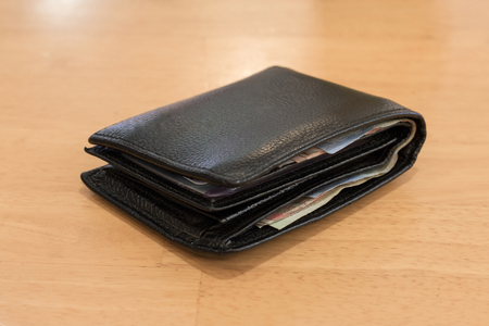 black leather wallet with banknotes for men on Background woodの写真素材