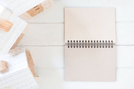 Blank paper notebook with Miniature house model on white wood backgroundの写真素材