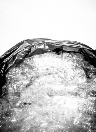 Separate plastic water bottles with garbage bag ready for recycle on white background and black and...