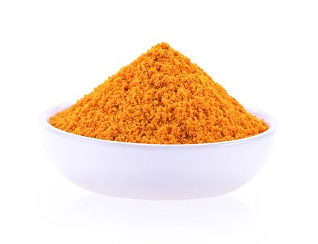 Turmeric powder in a separate ceramic cup on a white background.の写真素材