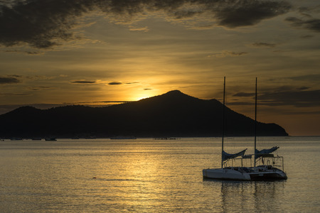 sunset over sea with sailboatの写真素材