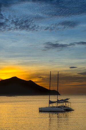 sunset over sea with sailboatの写真素材