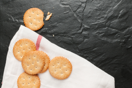 cracker stacked on white fabric over black graniteの写真素材